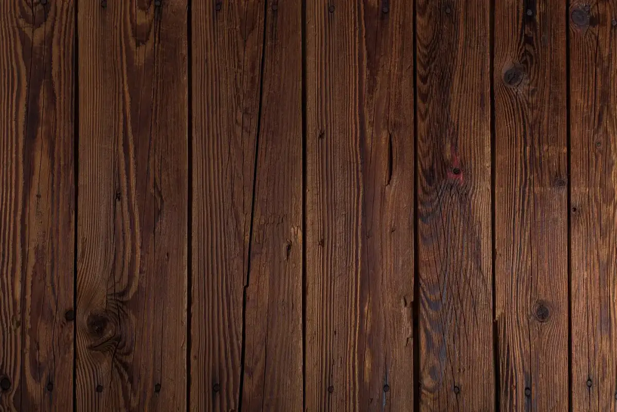 Dark timber boards with narrow gaps and checks running along the grain
