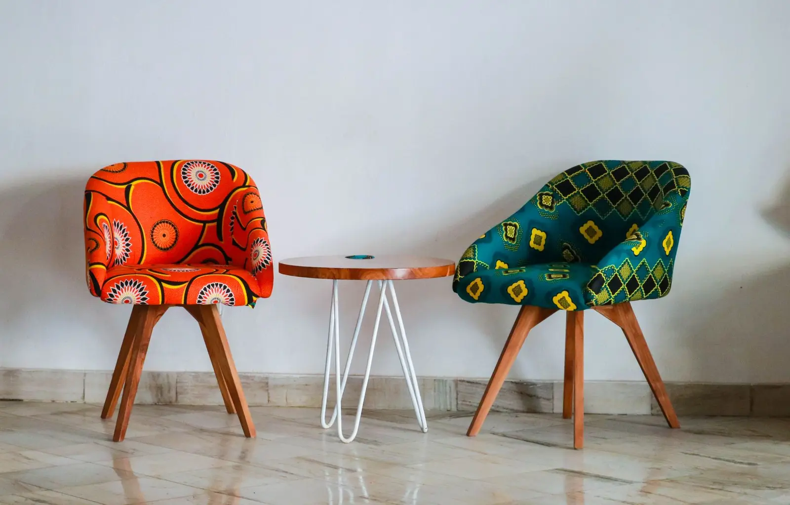 Two upholstered chairs with bold patterned cloth and timber legs
