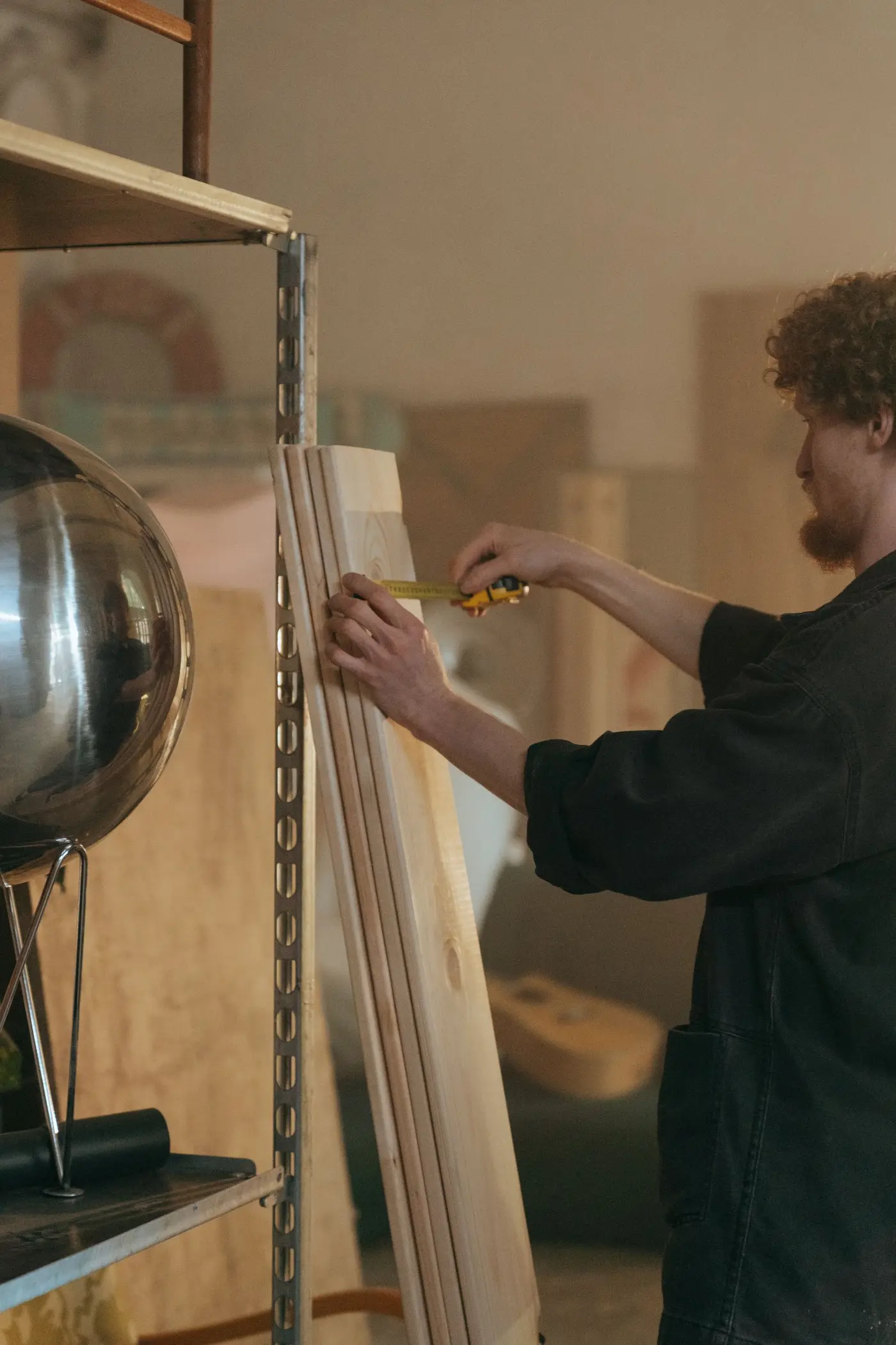 A person measuring the edge of a stack of boards with a tape