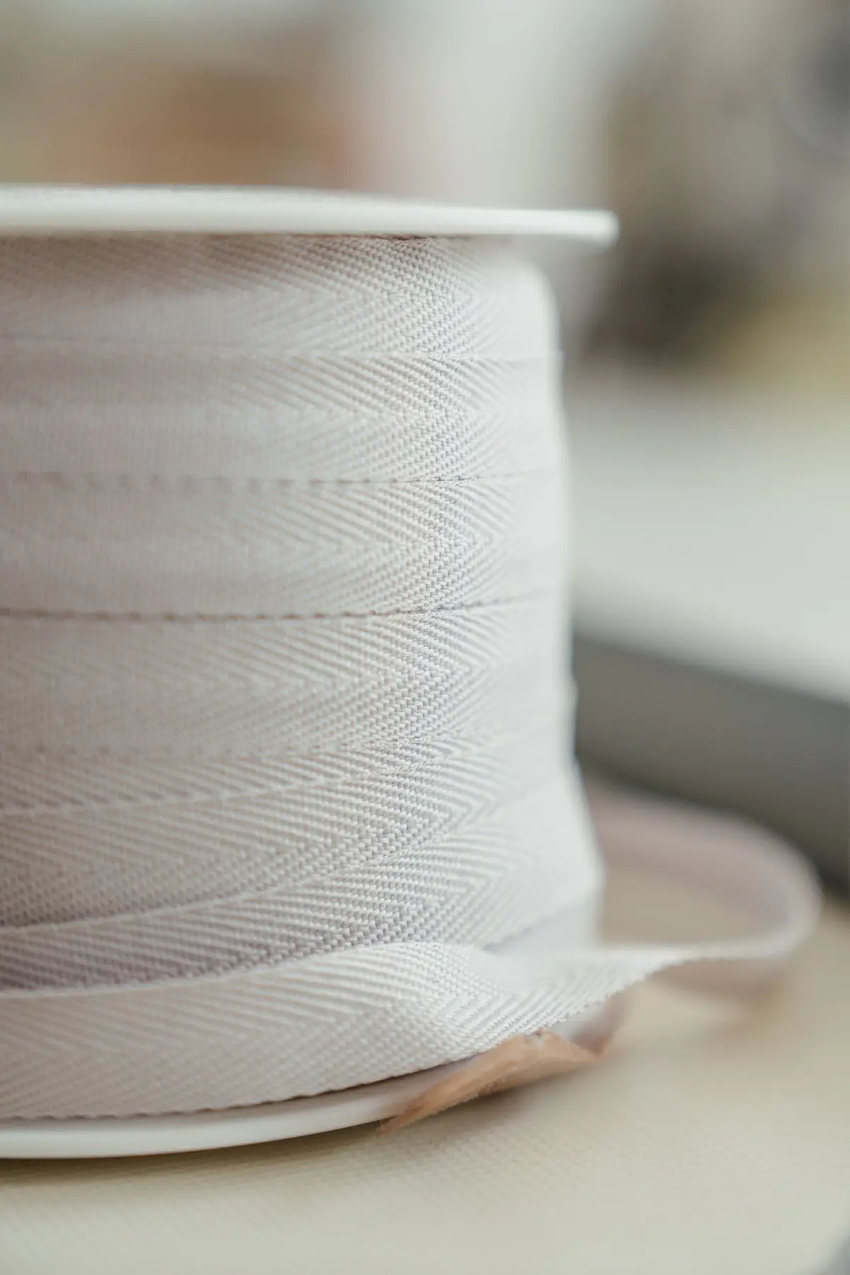 A roll of pale woven tape with a tight herringbone structure