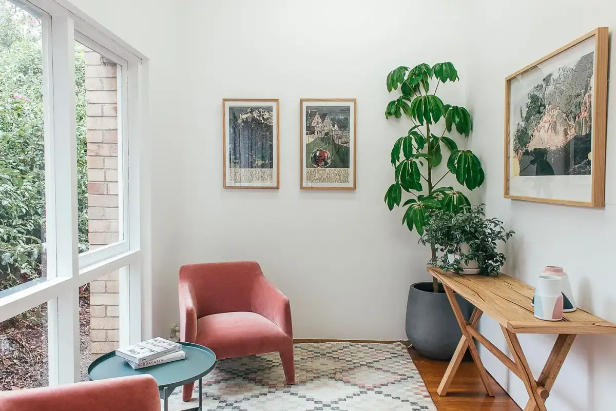 A chair and a timber table placed beside a tall window